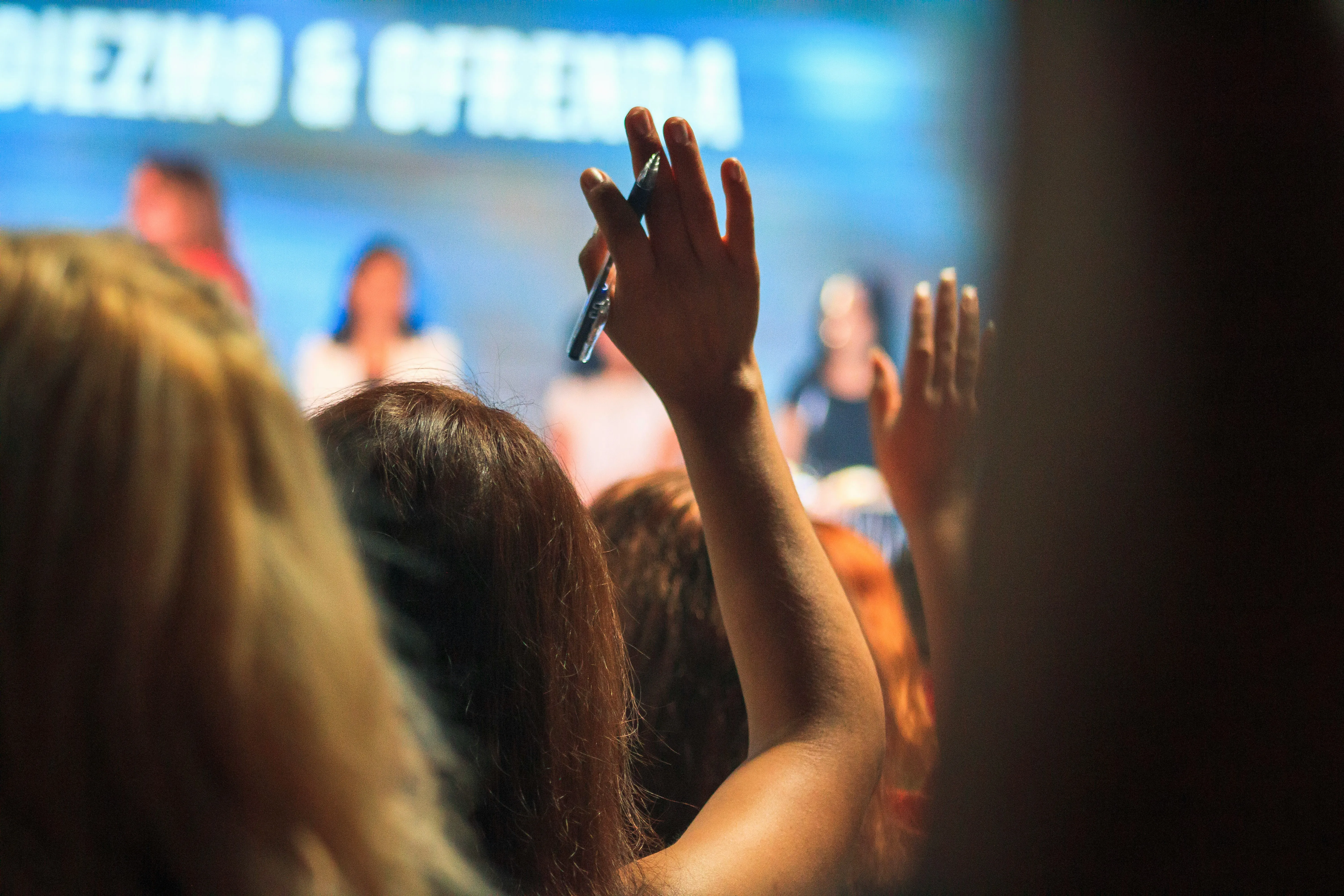 Engaged audience with hands raised